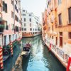 Góndola con personas navegando en canal de Venecia.