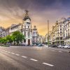 Imagen de la calle con tráfico en la Metrópolis de Madrid España. Cielo al atardecer.