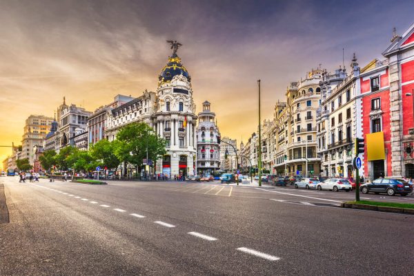 Imagen de la calle con tráfico en la Metrópolis de Madrid España. Cielo al atardecer.