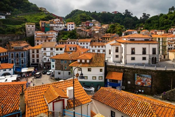 Imagen aérea de edificios con tejas de pueblo de Asturias. Cielo nublado.