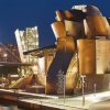 Museo Guggenheim en la ciudad de Bilbao iluminado de noche. Puente, monumento araña.