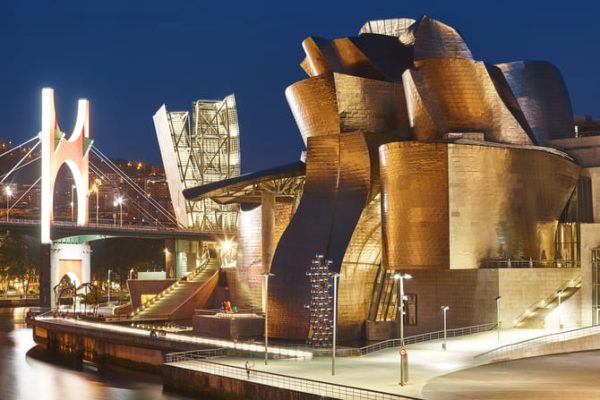 Museo Guggenheim en la ciudad de Bilbao iluminado de noche. Puente, monumento araña.